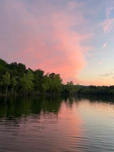 a body of water with trees and a sunset at Lake Eagle Rock Lodge in Eagle Rock +11 photos