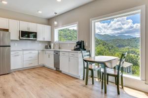 a kitchen with a table and chairs and a large window at Mtn Views and Stunning Fall Hikes Maggie Valley Apt in Maggie Valley