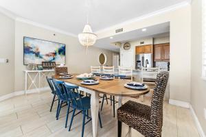 eine Küche und ein Esszimmer mit einem Holztisch und Stühlen in der Unterkunft Azure 501 - Beachfront Luxury & Stunning Ocean Views! in Fort Walton Beach
