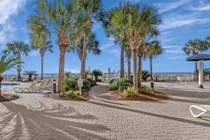 einen Kopfsteinpflasterweg mit Palmen in einem Park in der Unterkunft Azure 501 - Beachfront Luxury & Stunning Ocean Views! in Fort Walton Beach