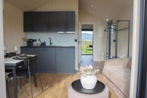 a kitchen and living room with a couch and a table at Golden Circle Cabins in Laugarvatn