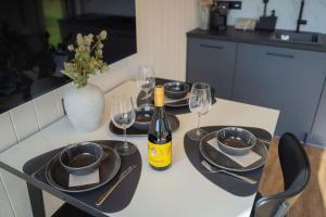 a table with glasses and a bottle of wine on it at Golden Circle Cabins in Laugarvatn