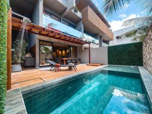 a swimming pool in front of a house at Kasa Kanui Milagres in São Miguel dos Milagres