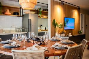 a dining room table with chairs and wine glasses at Kasa Kanui Milagres in São Miguel dos Milagres