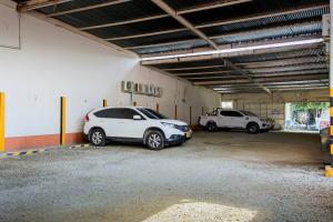 two cars parked in a parking lot in a garage at Posada Sueño Real in San Martín