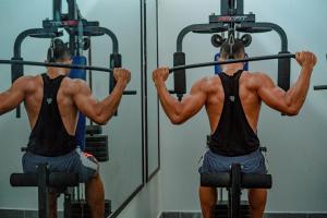 a man in front of a mirror lifting weights at Posada Sueño Real in San Martín
