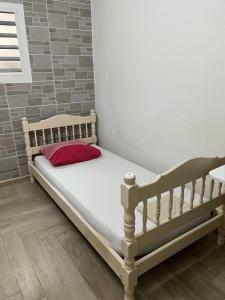 - un lit avec un oreiller rouge dans l'établissement Villa Liliana, à Sainte-Rose