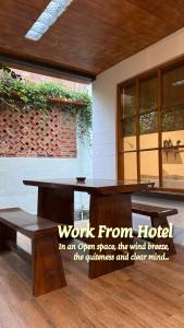 a wooden table and bench in front of a building at Tzy-No Cottage Yogyakarta in Balong
