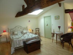 a bedroom with a bed and a table and chairs at Fleur de Vigne in Monnières