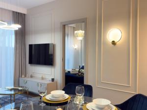 Una sala de estar con una mesa y un televisor. en URBAN APARTMENTS GLOBAL SkyLine, 25th floor No 05, Free Garage, Self Check-in, No Deposit, en Katowice