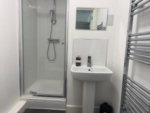 a white bathroom with a sink and a shower at Heathrow central suites in Colnbrook +43 photos