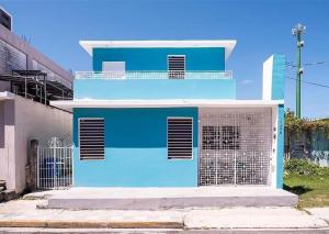 a blue building with a gate in front of it at La Casita de Ceiba in Ceiba