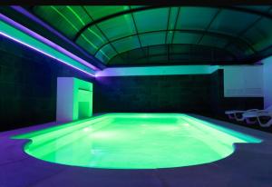 a large swimming pool with green and purple lights at Casa Rural La Granja de Torrehermosa TR-BA-00291 in Granja de Torrehermosa