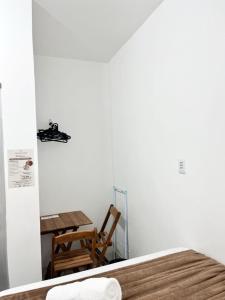 a bedroom with a table and a table and a chair at Pousada Marajó For You in Soure