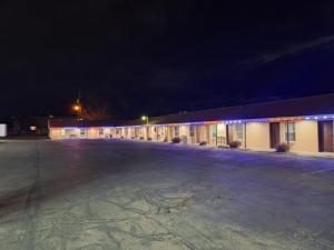 an empty parking lot in front of a building at night at Patriot Stay Motel in Vernal