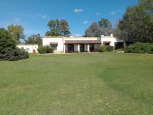 a house with a large yard in front of it at Hostel el Rincón in San Antonio de Areco