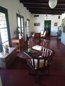 Una sala de estar con mesas y sillas y un sofá. en Hostel el Rincón, en San Antonio de Areco