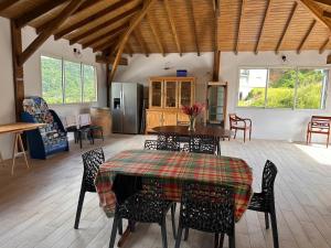 a room with a table and chairs and a kitchen at Résidence Fleur de Café - Villa 2 - La Désirade in Deshaies