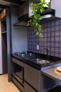 a kitchen with a sink and a black counter top at Chalé romântico e aconchegante in Irati +11 photos