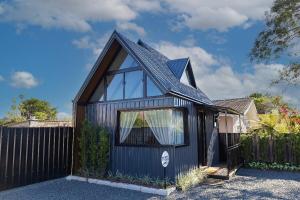 a black tiny house with a black roof at Chalé romântico e aconchegante in Irati
