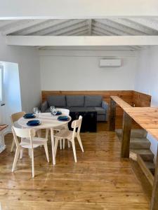 a dining room with a table and chairs and a couch at Casa do Octavia in Corvo