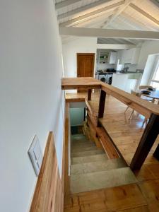 a kitchen with a wooden table and stairs in a room at Casa do Octavia in Corvo