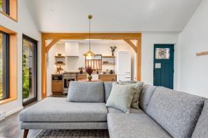 a living room with a couch and a kitchen at Fogged Inn in Ucluelet +23 photos