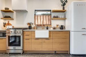 a kitchen with wooden cabinets and a white refrigerator at Fogged Inn in Ucluelet