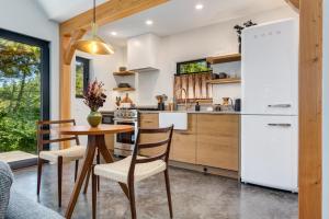 a kitchen with a table and chairs and a refrigerator at Fogged Inn in Ucluelet