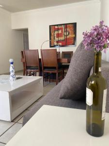 a living room with a bottle of wine on a table at Bonita Casa Centrica a 10 min del malecon in La Paz +15 photos