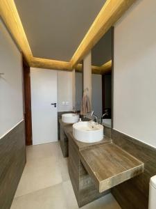 a bathroom with two sinks and a large mirror at Apartamento aconchegante na Serra de São Bento in Serra de São Bento