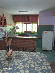 una cocina con una mesa y un jarrón con flores. en Ground Floor Loft 5 personas, en San Bernardo