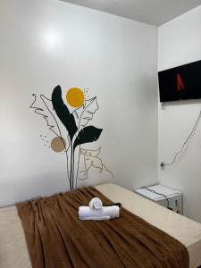 a bedroom with a bed with a flower on the wall at Pousada Marajó For You in Soure