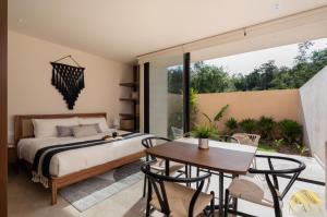 a bedroom with a bed and a table and chairs at Peregrina Tulum Lux Aparthotel in Tulum +50 photos