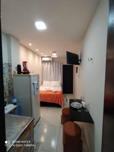 a small room with a bed and a kitchen at Casa Laranja no Centro de Pipa a 3 min das Praias in Pipa +7 photos