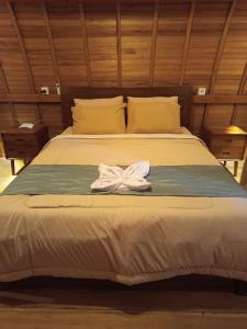 a bed with a white towel on top of it at Kersa Guest House in Sidemen