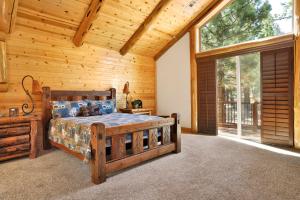 a bedroom with a bed in a log cabin at Luxury Heavenly Lodge Big Bear~ Hot Tub + Pool Table in Big Bear Lake