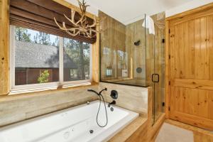 a bathroom with a tub and a window at Luxury Heavenly Lodge Big Bear~ Hot Tub + Pool Table in Big Bear Lake +38 photos