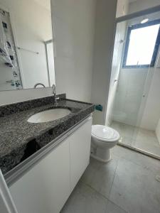 une salle de bain avec un lavabo et des toilettes dans l'établissement Ap em Juazeiro do Norte com dois quartos com cama de casal e ar condicionado, à Juazeiro do Norte
