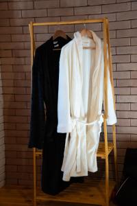 a wooden rack with a sweater and a jacket at Chalé Canto dos Pássaros MG in Paraisópolis