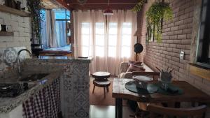 a kitchen with a table and a living room at Chalé Canto dos Pássaros MG in Paraisópolis +26 photos