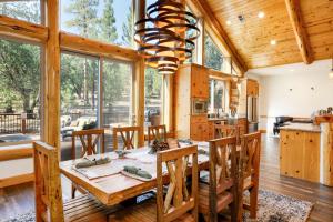 a dining room with a wooden table and chairs and a chandelier at Luxury Heavenly Lodge Big Bear~ Hot Tub + Pool Table in Big Bear Lake