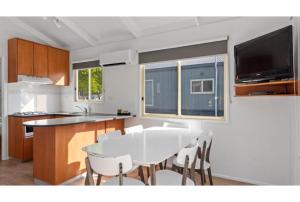 a kitchen and dining room with a white table and chairs at Discovery Parks - Maidens Inn Moama in Moama