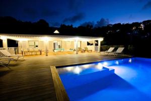 una piscina frente a una casa por la noche en 4bd Villa with Panoramic Sea View and Infinity Pool, en Anse Marcel 