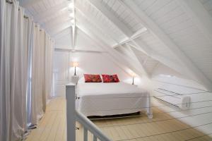 1 dormitorio blanco con 1 cama con 2 almohadas rojas en 4bd Villa with Panoramic Sea View and Infinity Pool, en Anse Marcel  15 fotos más