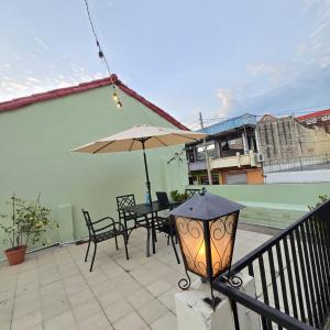 a patio with an umbrella and a table and chairs at Napoli Centro in Santa Ana