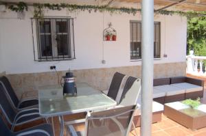 a patio with a table and chairs and a bench at casa vacacional con piscina privada in Sant Cebrià de Vallalta