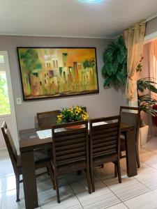 a dining room table and chairs with a painting on the wall at Casa dei Nonni in Garibaldi