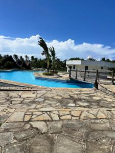 a stone walkway next to a swimming pool at Golden Sun in Diani Beach