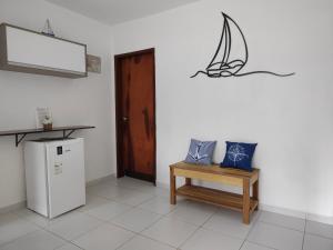 a room with a table and a bench and a door at Sitio Recanto Feliz-beira-mar, pertinho da Igrejinha in Praia dos Carneiros